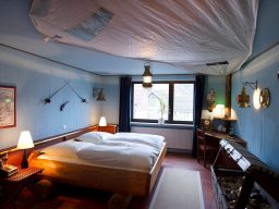 Gemütliches Schlafzimmer mit zwei Betten, blauen Wänden und dekorativen Elementen.