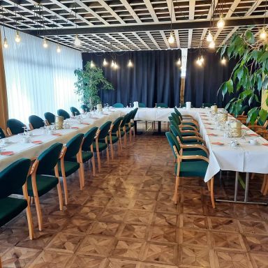 Elegant Veranstaltungstisch mit grünen Stühlen in einem hellen Raum.