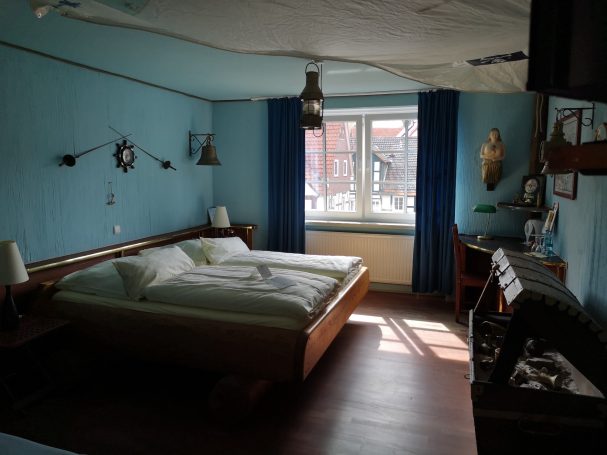 Helles Schlafzimmer mit einem Doppelbett, blauen Wänden und Holzdekor.