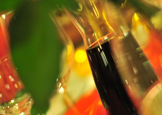 Eine Flasche mit dunklem Getränk, umgeben von verschwommenen Farben und Lichtern.